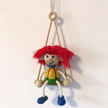 Panáček vlasatec s červenými vlasy na houpačce